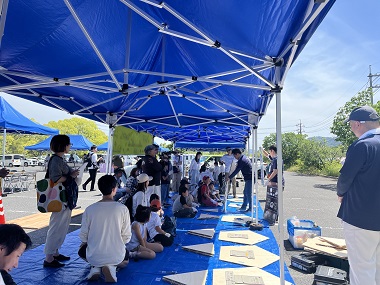 Image: Participants listening to an instructor in front of parts