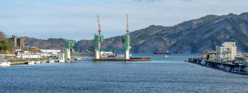 図版:上流側から見る閉伊川河口部。左岸側3基の堰柱の構築が完了している(2021年1月)