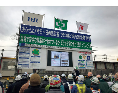 図版:朝礼台に設置した大型のスクリーンで過去の災害事例や対策を周知している