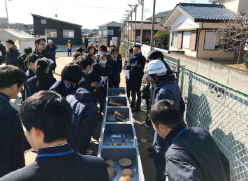 図版:出土品を見学する様子。生徒たちも興味津々