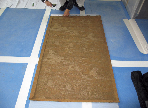 図版:役員室の白い壁下から発見された創建時の織り物クロスは洗浄し,復原