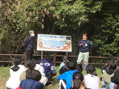 図版：児童にホタルの生息環境を説明する様子