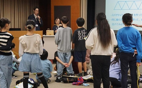 図版：スパゲッティで作った模型実験を見学する様子