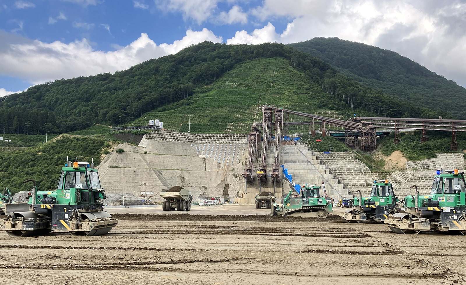 10数台の自動化重機が連携して堤体打設を行う成瀬ダム堤体の様子